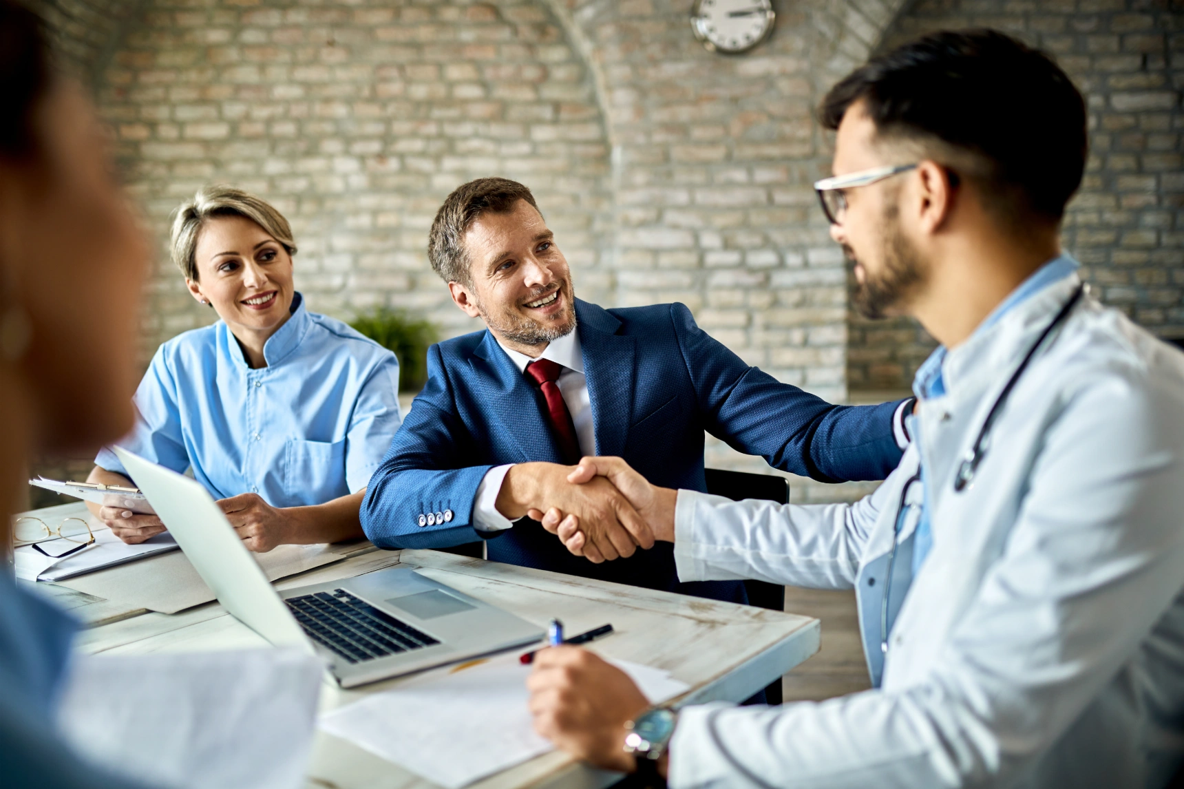happy-financial-advisor-male-doctor-shaking-hands-after-successful-meeting-office